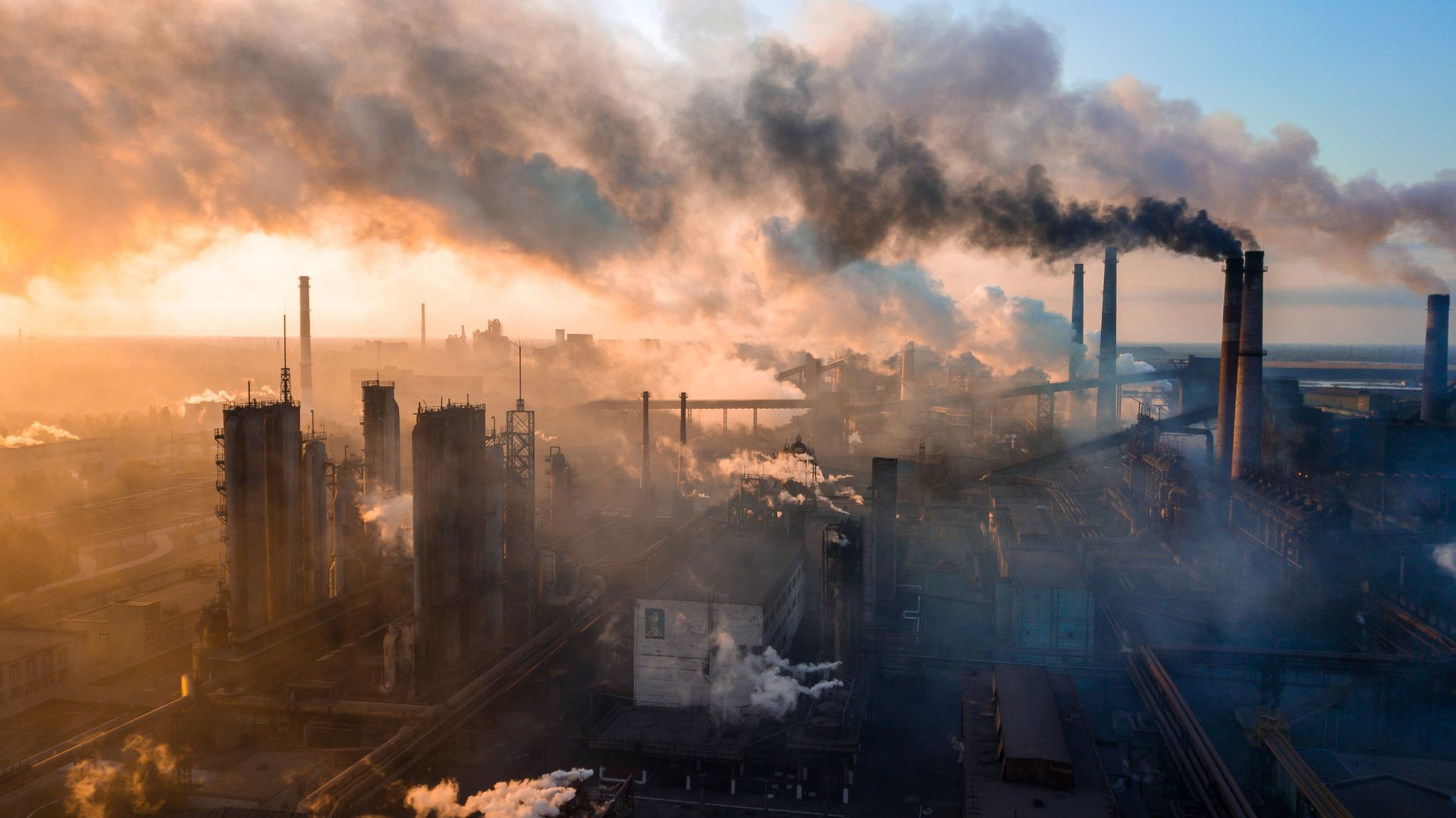 Industrial plant releasing heavy emissions at sunrise